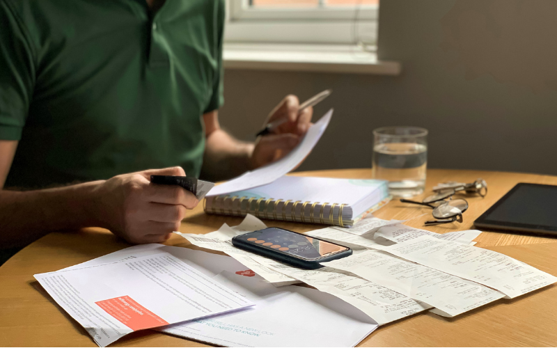 Person sitting at a table with papers and calculator